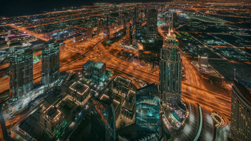 Aerial night view of Damac Hills 2 showcasing vibrant city lights and architectural marvels.